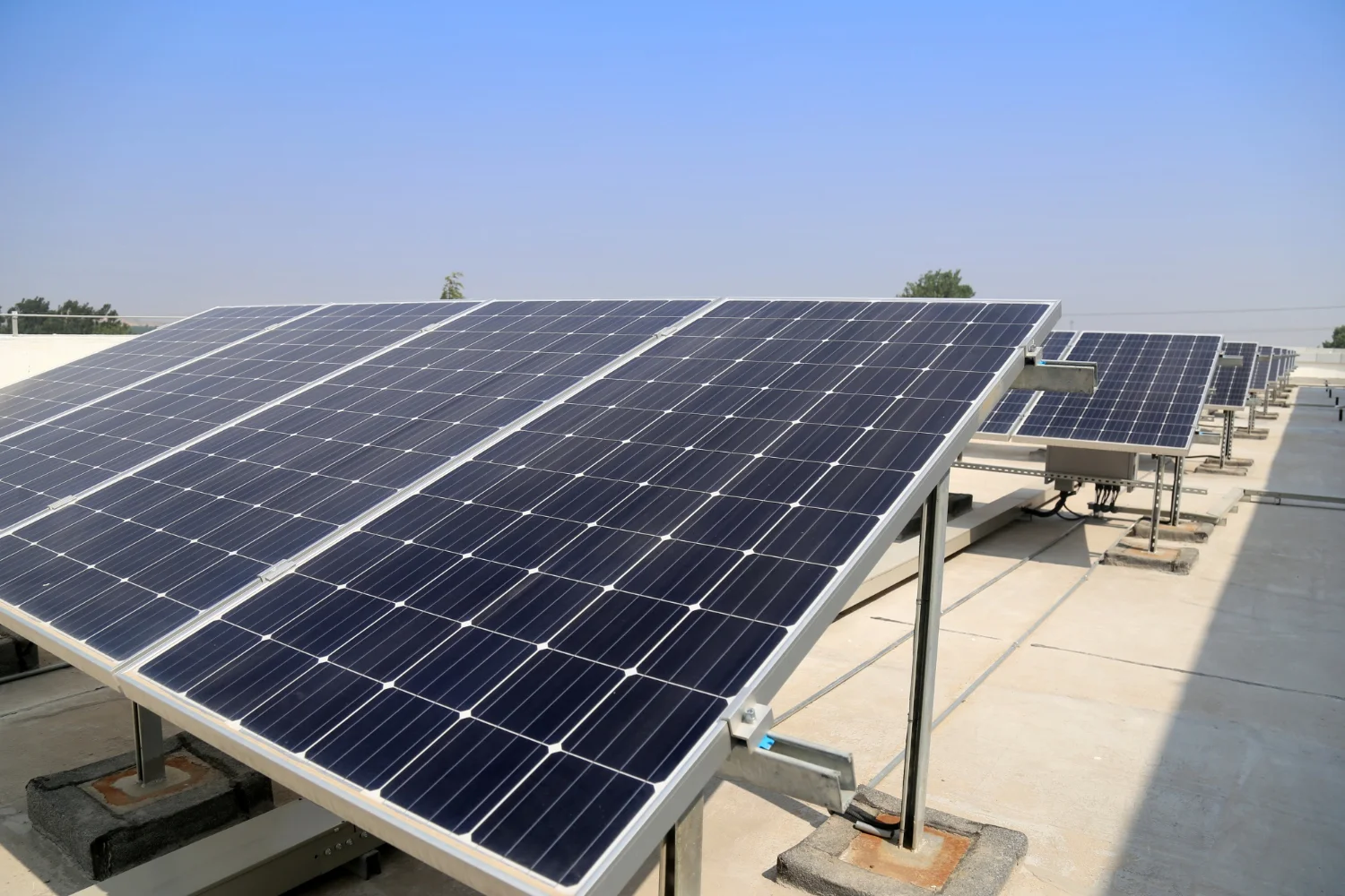Rooftop solar panel array under clear blue sky