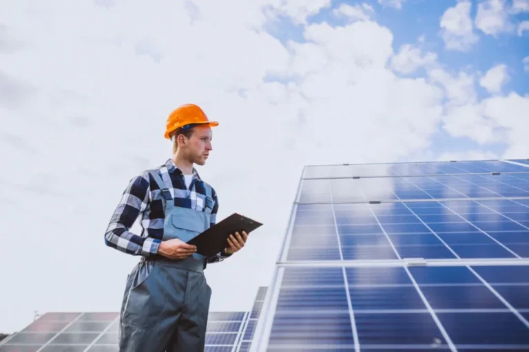 Technician inspecting solar panels with clipboard under cloudy sky